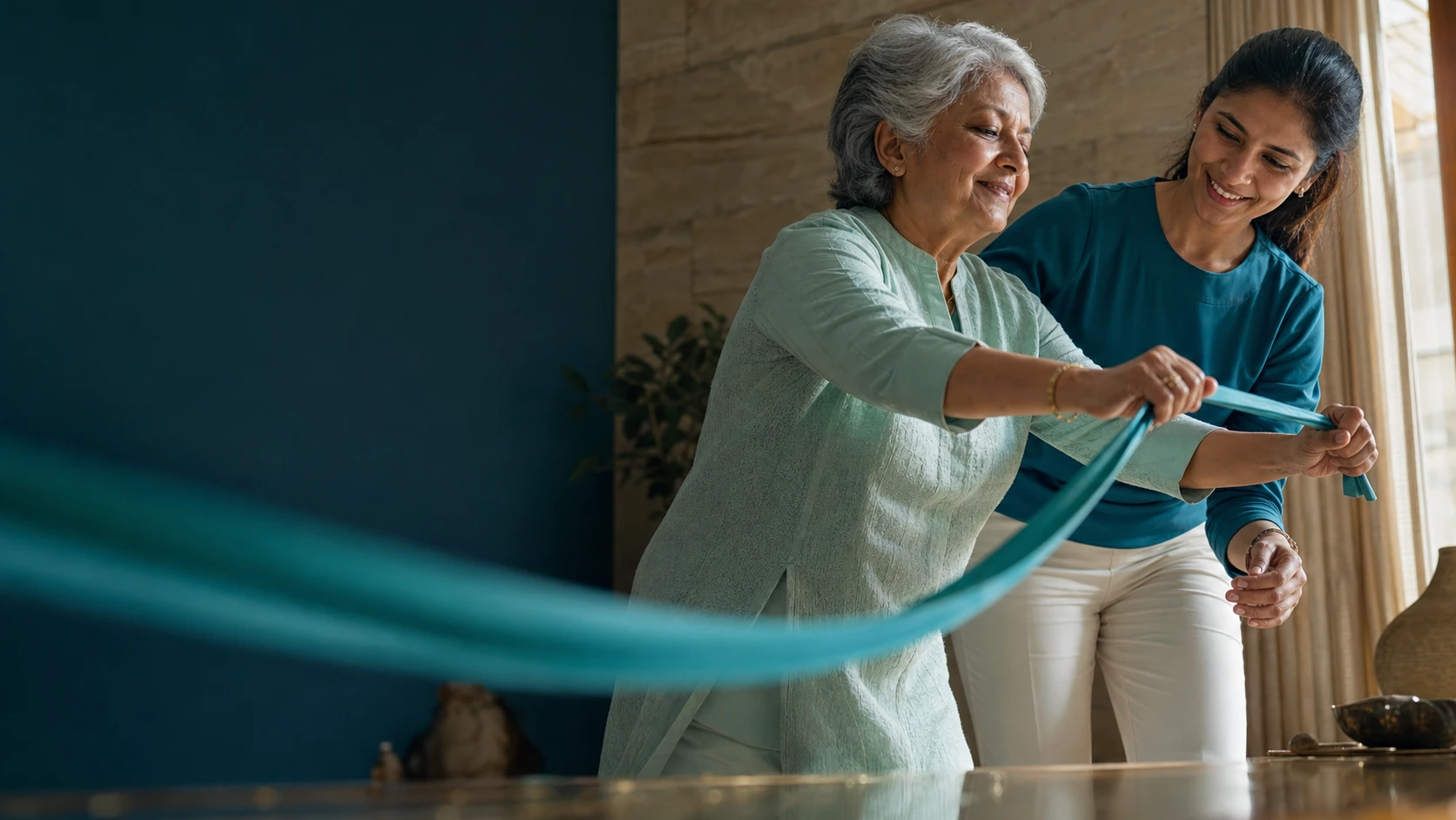 An older woman and a home rehabilitation professional exercising together with a resistance band